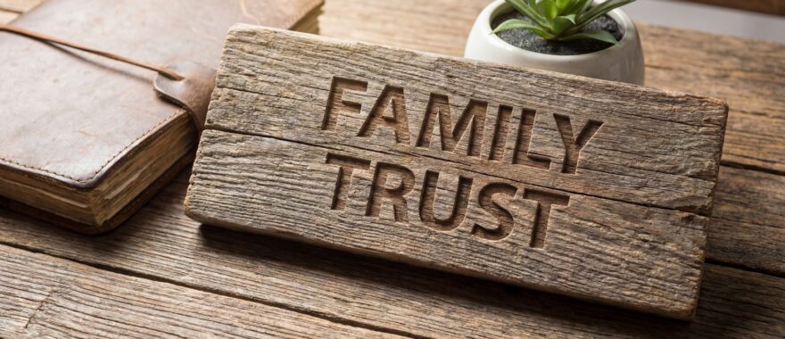 שלט עץ חרוט עם המילים FAMILY TRUST
